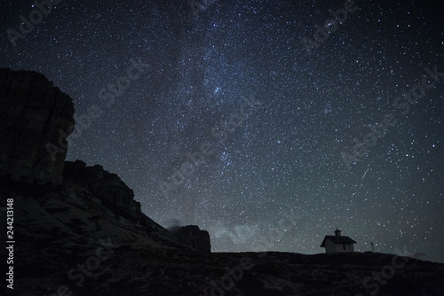 Milky way on the horizon. View from mountain with small building on it