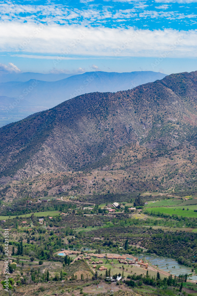 Obraz premium view of the valley between the mountains. view from above. to a residential valley. around the chilean mountains. below the village and ponds