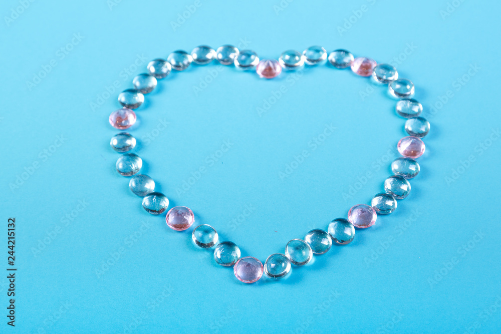 Heart of beads and pebbles on a blue background. Heart of beads and pebbles on a blue background.