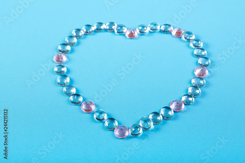 Heart of beads and pebbles on a blue background.