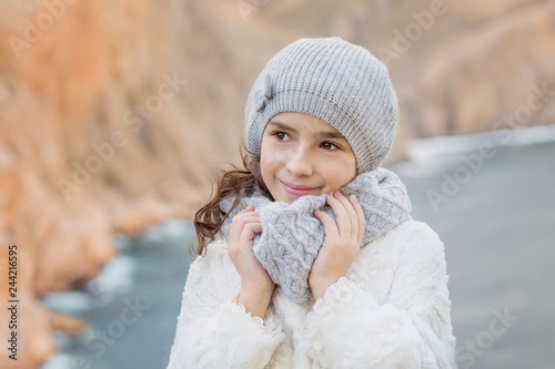 Portrait of a cute little girl on the background of the sea