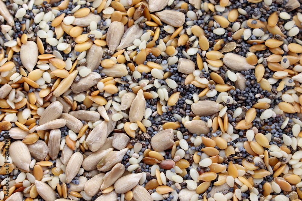 A close up photograph of mixed seeds - linseeds, flaxseeds, chias seeds and poppy seeds. raw, organic ingredients. A close up photograph of mixed seeds - linseeds, flaxseeds, chias seeds and poppy seeds. raw, organic ingredients.