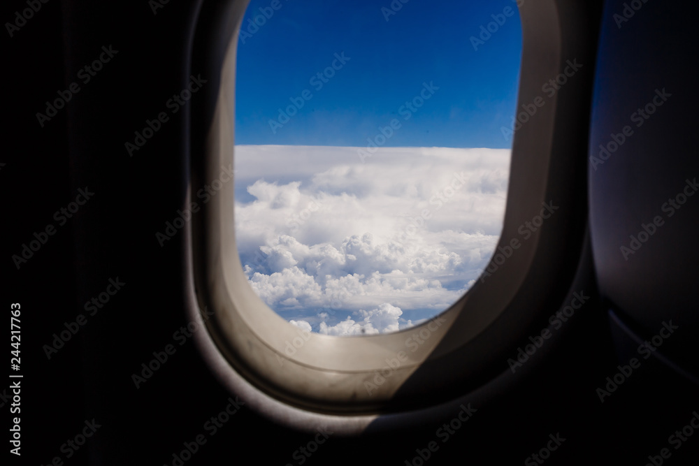 blue sky and cloud with looking out an airplanes porthole window during a flight , image using for sky and interior airplane concept