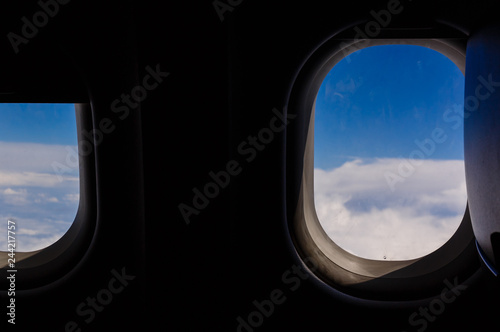 blue sky and cloud with looking out an airplanes porthole window during a flight   image using for sky and interior airplane concept