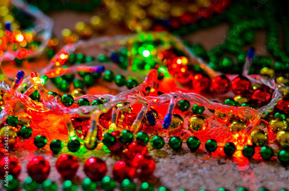Close-up of multicolored Christmas beads for decorating the Christmas tree with a soft blurred background. Christmas tinsel