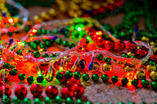 Close-up of multicolored Christmas beads for decorating the Christmas tree with a soft blurred background. Christmas tinsel