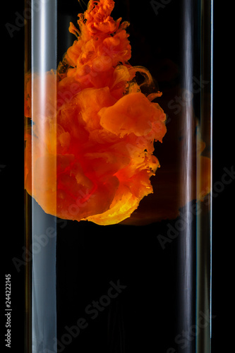 Acrylic paints dissolve in water on a black background. Abstract background.