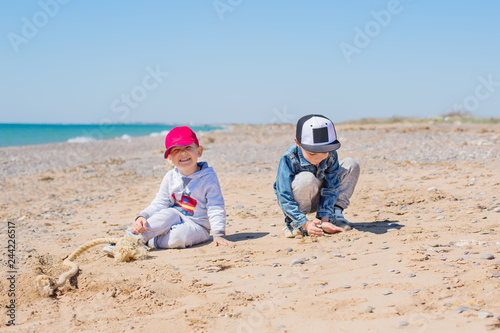 Two Young Children Playing Toys in the Sand