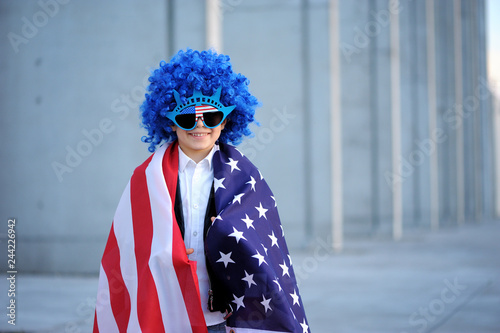 Happy handsome boy  smiling and waving American flag outside, wearing  Jackster Bandana. Child celebrating 4th july - Independence Day of USA. photo