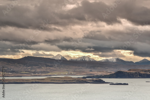 Isle of Skye in Scotland - view on Cuillin Hills covered in December snow and exposed to sunset light - overcast sky