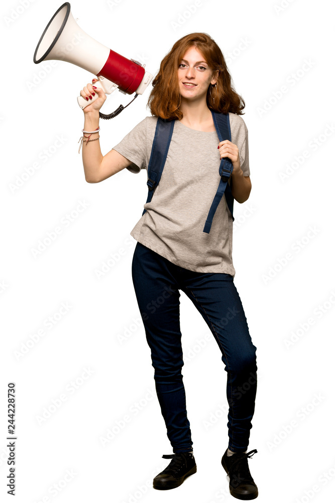 A full-length shot of a Young redhead student holding a megaphone over isolated white background A full-length shot of a Young redhead student holding a megaphone over isolated white background