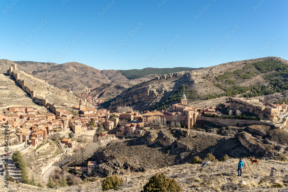  Hombre joven y su perro mirando un hermoso pueblo amurallado en España, llamado Albarracín.
