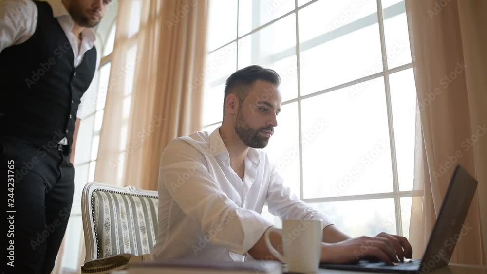 Boss checks intern working on laptop over window background. Boss checks intern working on laptop over window background.