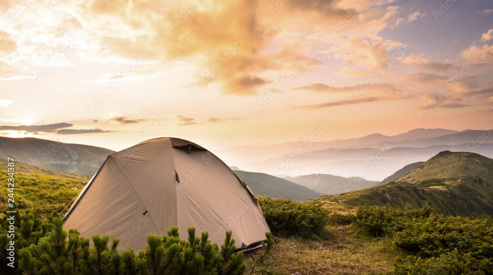 Tourist tent in hight mountains summer sunset
