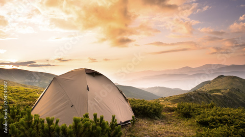 Tourist tent in hight mountains summer sunset