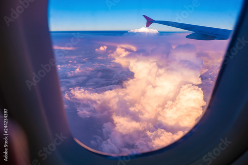 View from airplane window, sky and clouds at sunset or sunrise