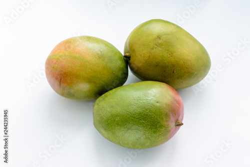 Three ripe mangoes on a white background. Mangoes are juicy stone fruit (drupe) from numerous species of tropical trees belonging to the flowering plant genus Mangifera. Tropical fruit.