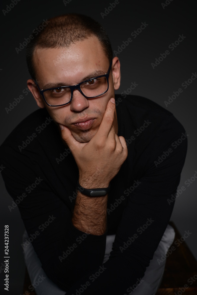 a man in a black jacket shows emotions in the Studio on a black background a man in a black jacket shows emotions in the Studio on a black background