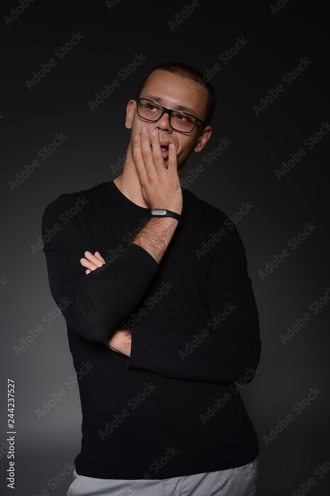 Fototapeta premium mężczyzna w czarnej kurtce pokazuje emocje w Studio na czarnym tle
