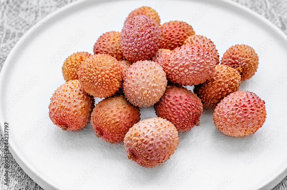 Fresh organic lychee fruit in a bowl on a rustic wooden background. Healthy vegan food concept. Close-up Fresh organic lychee fruit in a bowl on a rustic wooden background. Healthy vegan food concept. Close-up