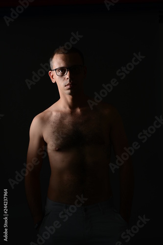 a man shows his torso and posing in the Studio on a black background © korotkovkris