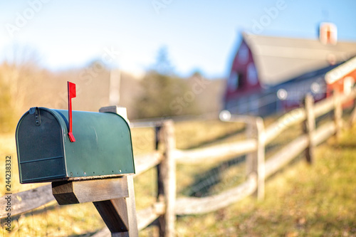 mail box with raised mailbox flag outside. American mailbox. rural view, blurred background