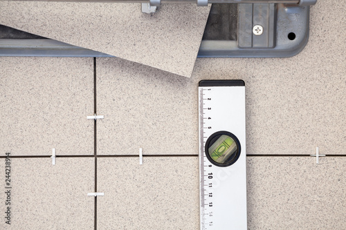Tile-cutter, building level for tile paving, background photo