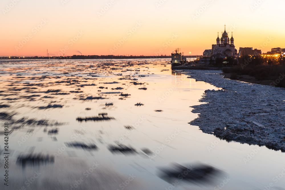 Fototapeta premium Ice drift in Northern Dvina river in Arkhangelsk, Russia. Beautiful ice motion evening landscape.