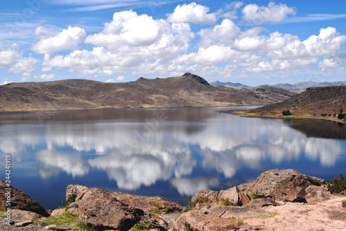 Lake in the mountains with the clouds reflecting in the water. Photo taken nearby Puno, Peru