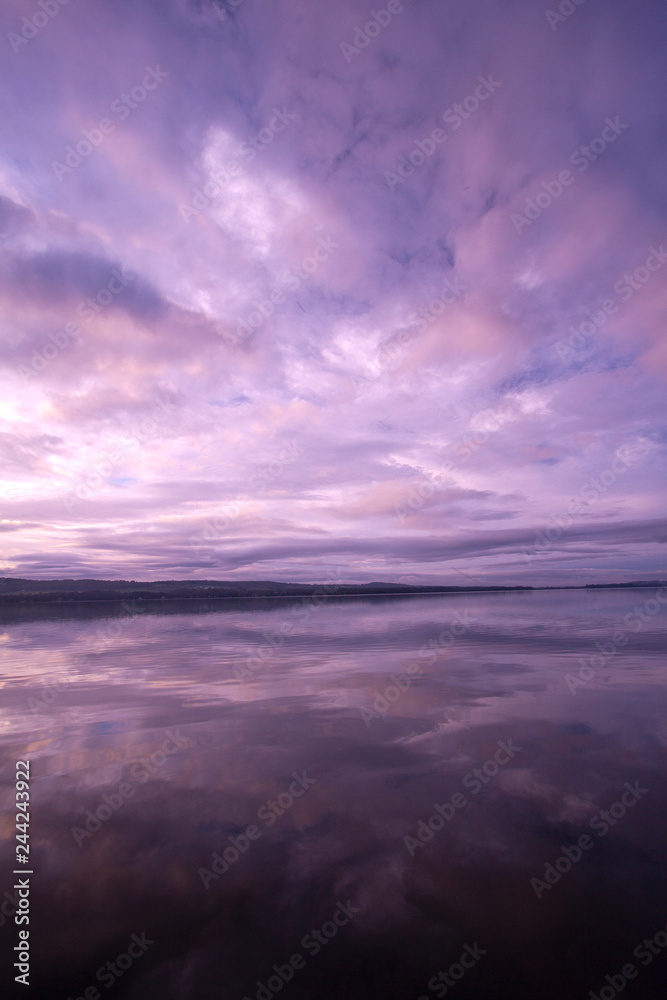 Brilliant pastel pinks and purples in sunrise over still waters of Lake Carmi in Franklin, VT, USA