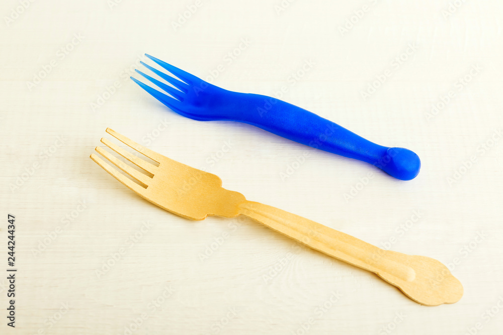 Disposable plastic and wooden forks on a white background Disposable plastic and wooden forks on a white background