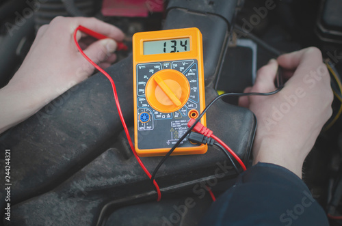 Εκτύπωση καμβά Auto electrician engineer is checking a car battery charge by multimeter