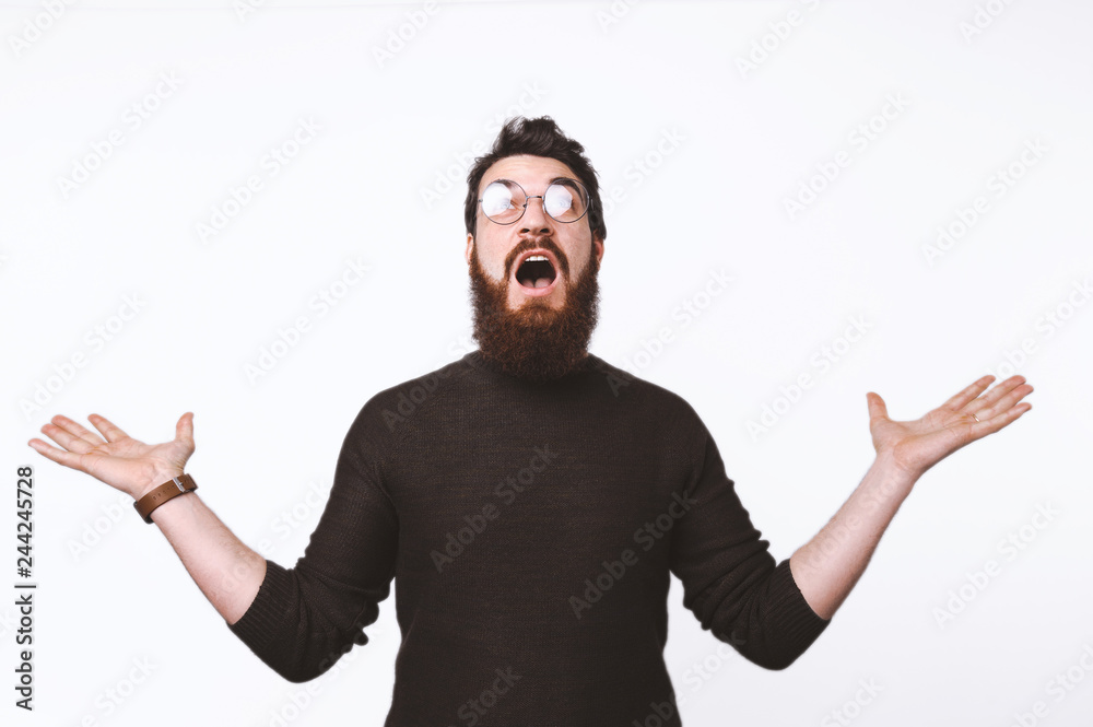 Portrait of facinated bearded guy oking up with happy expression and raising hands Portrait of facinated bearded guy oking up with happy expression and raising hands