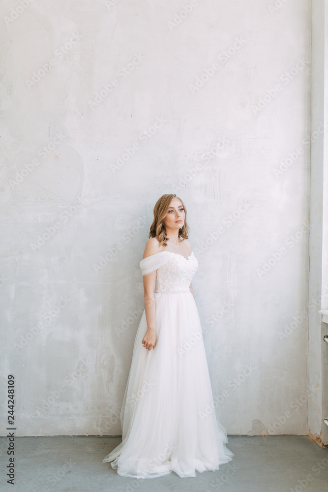 Fees in the interior Studio in the European style. The bride in a white wedding dress. Fees in the interior Studio in the European style. The bride in a white wedding dress.