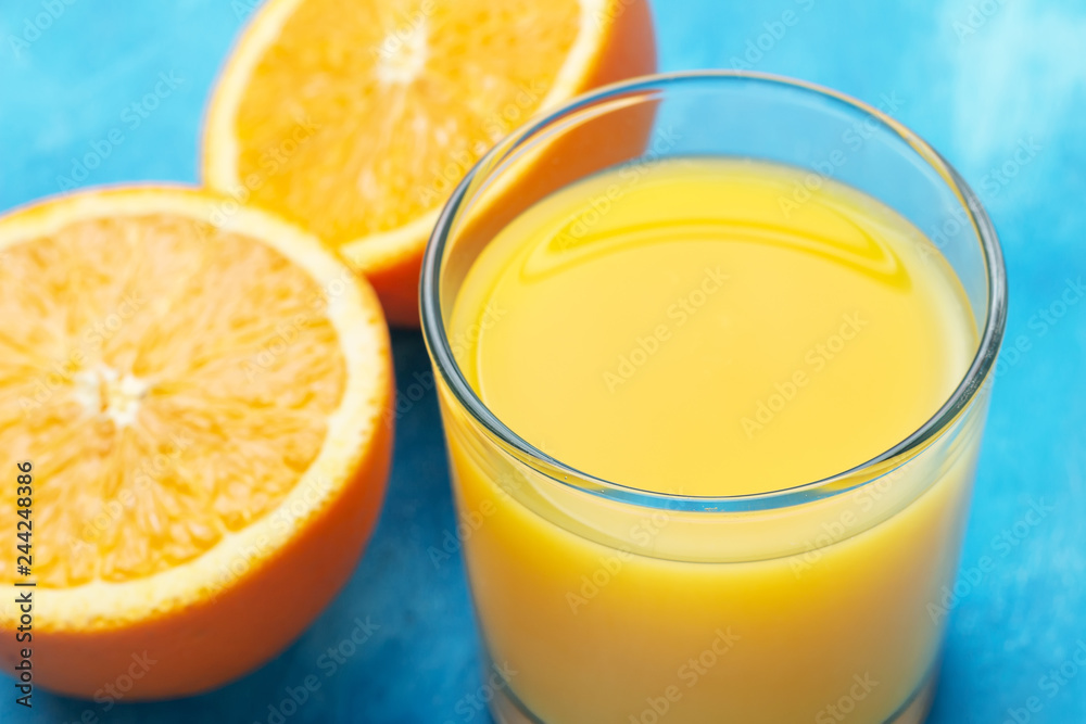 Orange fresh drink, glass of juice and ripe citrus fruits on a blue background