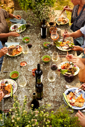 Family eating at outdoor dinner party photo