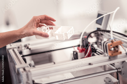 Closeup of womans hand holding detail under 3D printe