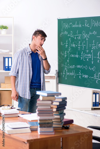 Young male student studying math at school