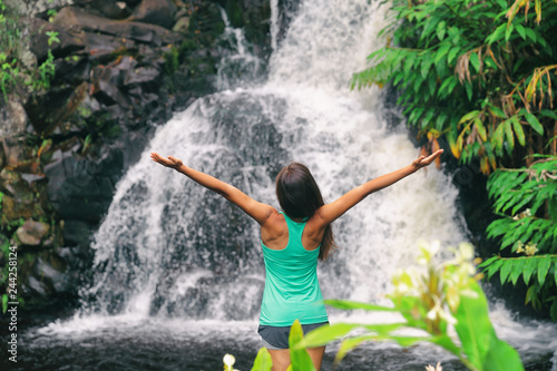 Hawaii travel nature waterfall woman hiker at Canyon Trail Waipoo Falls in Waimea, Kauai island, USA. Freedom happy girl with open arms meditating yoga in rainforest. © Maridav