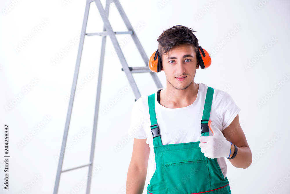 Young worker with earmuffs in noise cancelling concept Young worker with earmuffs in noise cancelling concept