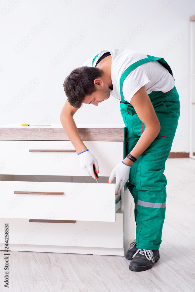Young worker with cupboard in home renovation concept 