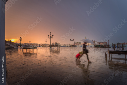a girl in a hurry on rainy early morning with suitcase