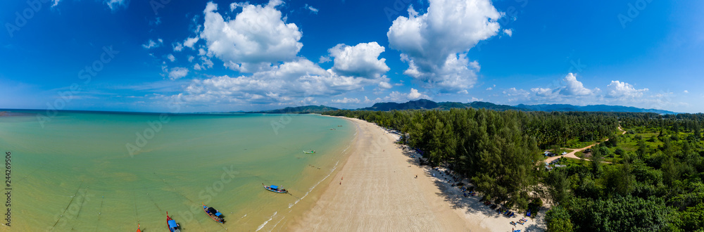 Aerial panoramic view of a beautiful tropical beach with traditional boats surrounded by lush greenery (Khao Lak, Thailand) Aerial panoramic view of a beautiful tropical beach with traditional boats surrounded by lush greenery (Khao Lak, Thailand)