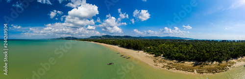 Aerial panoramic view of a tropical sandy beach and traditional longtail boats (Cape Pakarang, Thailand)