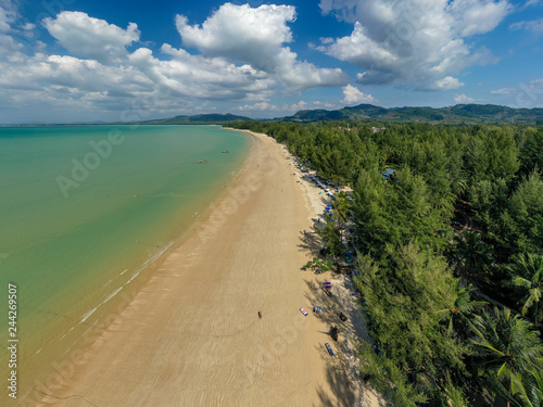Aerial drone view of a beautiful, quiet tropical beach surrounded by lush greenery