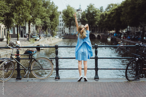 Canvas Print girl in a blue dress on the bridge in Amsterdam