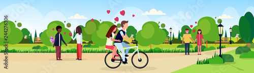 couples in love riding bicycle walking celebrating happy valentines day holiday concept mix race men women lovers in city urban park landscape background flat horizontal