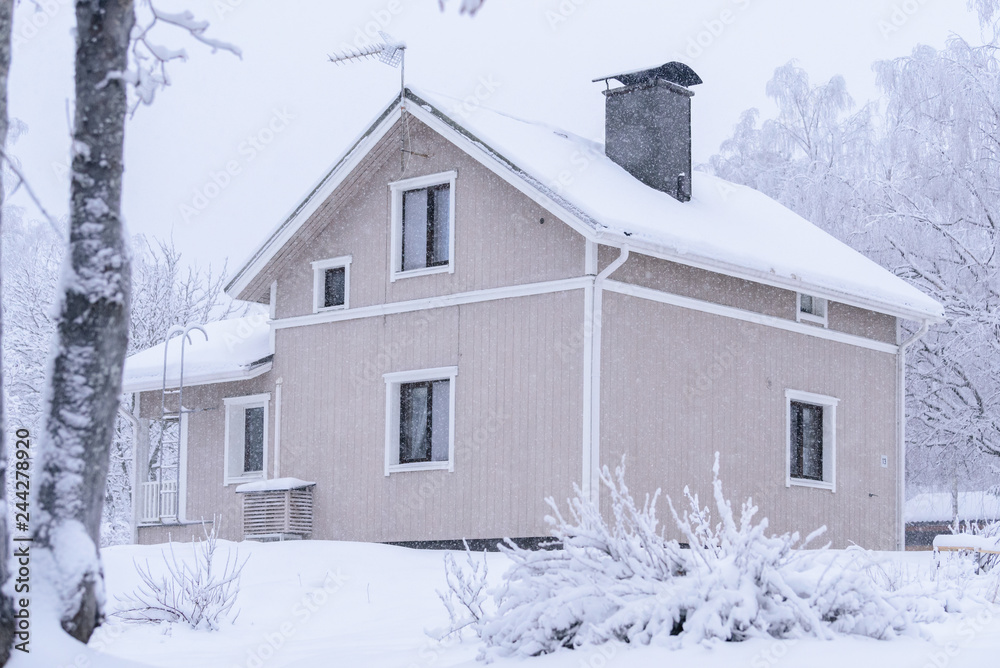 The house in the forest has covered with heavy snow and bad sky in winter season at Tuupovaara, Finland.