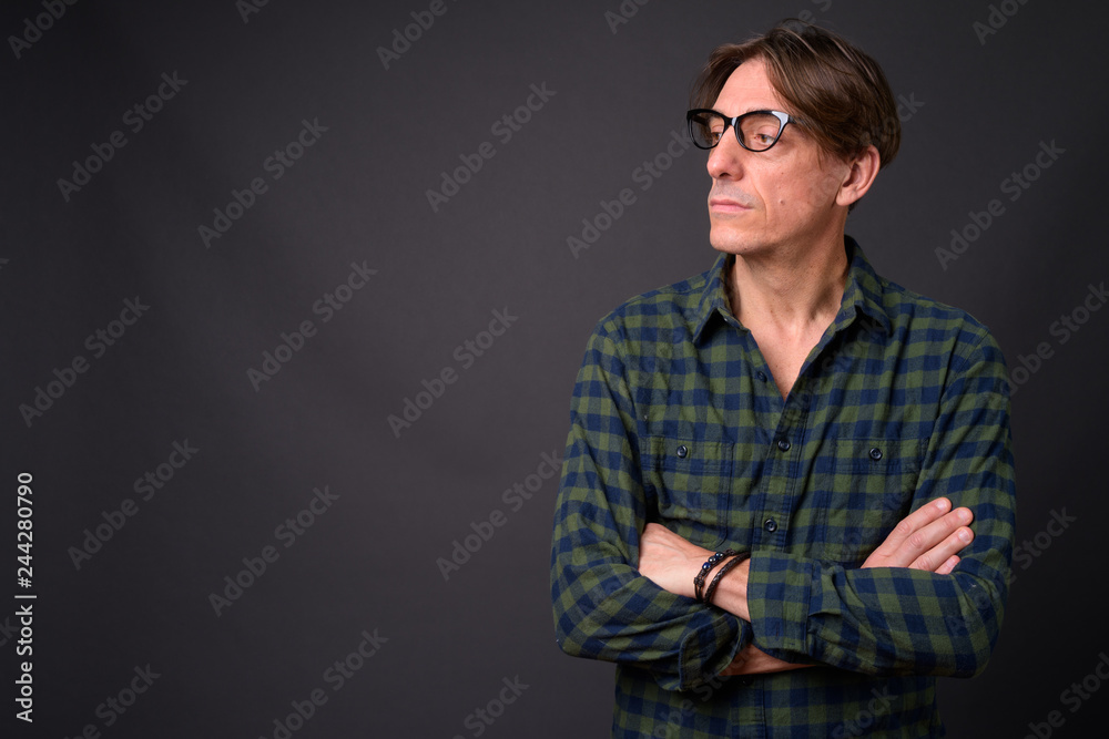 Fototapeta premium Mature handsome Italian man thinking against gray background