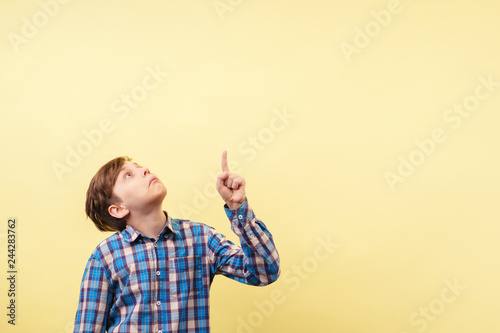 Foto shocked astonished amazed boy points with index finger at empty space, advertise